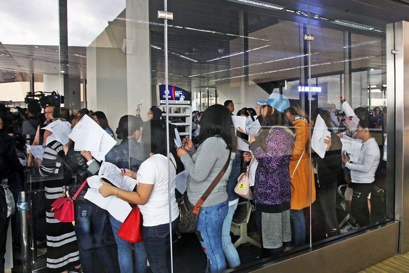 a group of people standing in a line papers in their hands